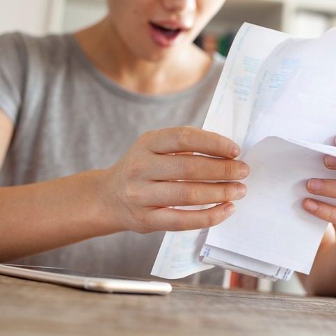 Person surprised while reading a bill.